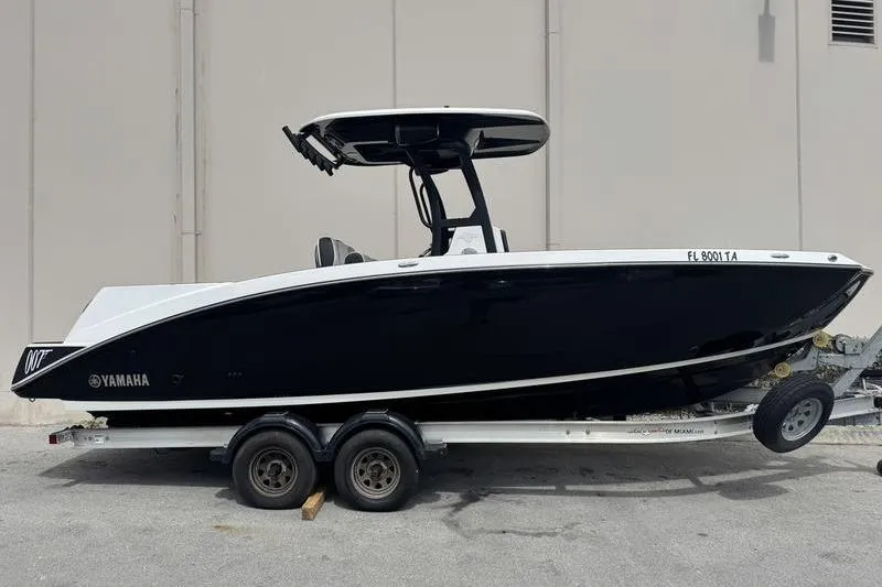 Slide: The Image of 2021 Yamaha Boats 255 FSH Sport E on trailer, sleek black design. - 6