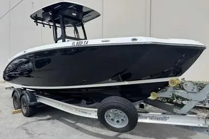 Slide: The Image of 2021 Yamaha Boats 255 FSH Sport E on trailer, black hull, side view. - 7
