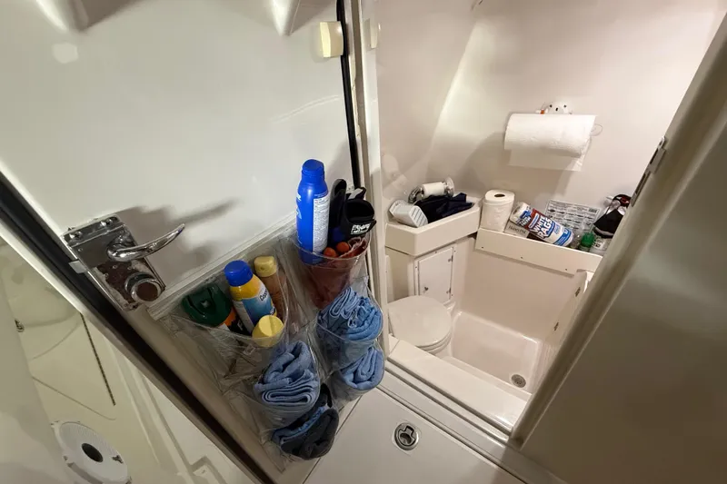 Slide: The Image of 2012 Jupiter 34 FS boat bathroom with storage, toiletries, and cleaning supplies. - 11