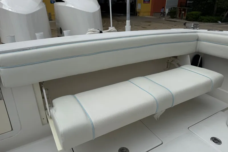 Slide: The Image of White cushioned seating on a 2012 Jupiter 34 FS boat, featuring foldable design. - 18