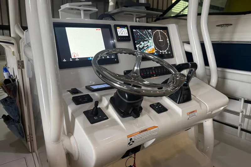 Slide: The Image of Control panel of a 2012 Jupiter 34 FS boat with navigation screens and steering wheel. - 4