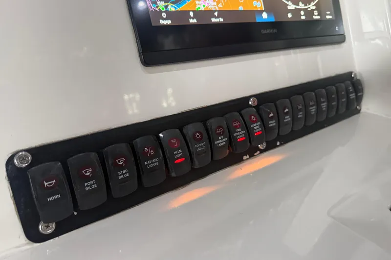Slide: The Image of Control panel of a 2012 Jupiter 34 FS boat with labeled switches and Garmin display. - 8