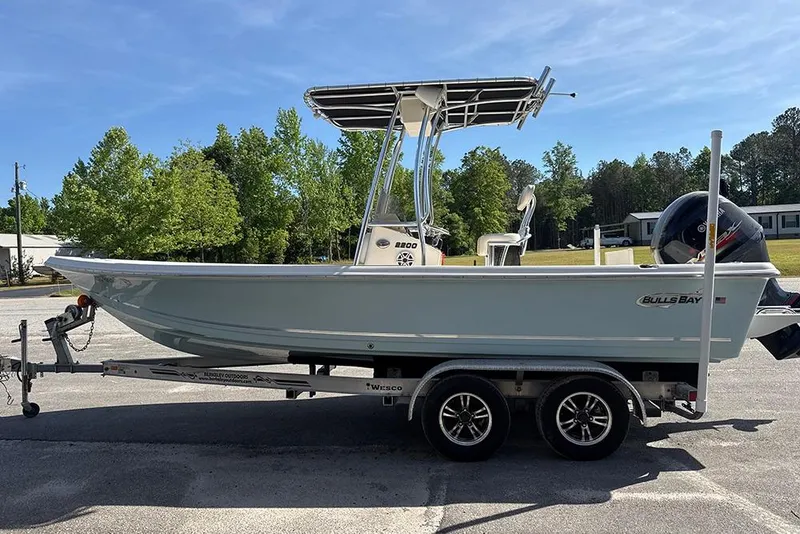Slide: The Image of 2021 Bulls Bay 2200 boat on trailer, parked outdoors with trees in background. - 15