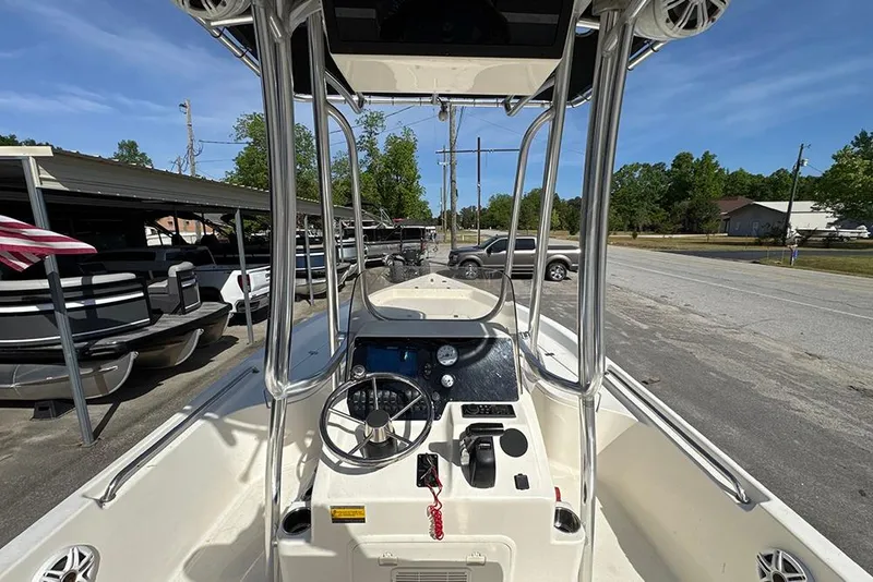 Slide: The Image of 2021 Bulls Bay 2200 boat interior with steering console and T-top, parked outdoors. - 20