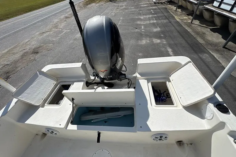 Slide: The Image of 2021 Bulls Bay 2200 boat stern view with open storage compartments and outboard motor. - 23