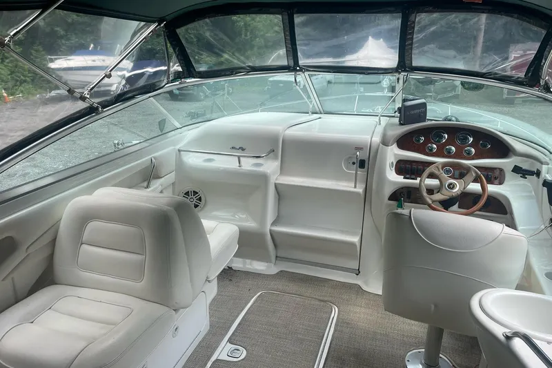 Slide: The Image of Interior of a 2001 Sea Ray 280 Sun Sport boat with white seating and dashboard. - 11