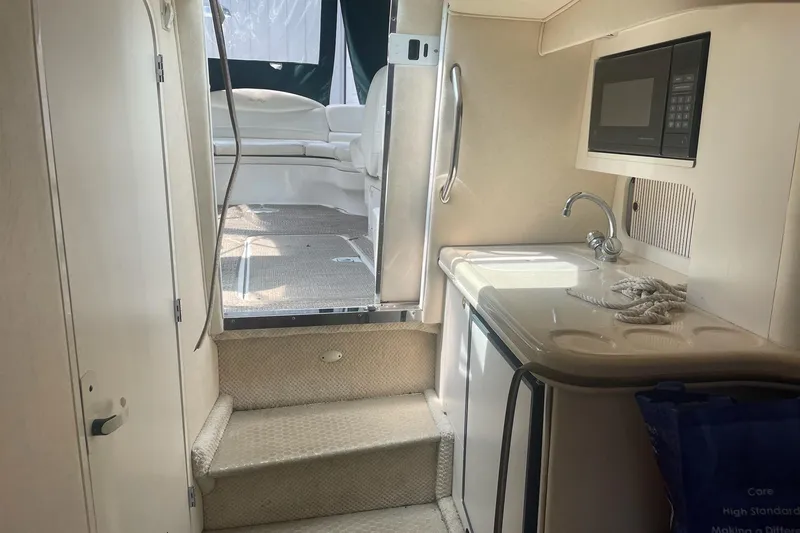 Slide: The Image of Interior of 2001 Sea Ray 280 Sun Sport boat with kitchenette and seating area. - 18