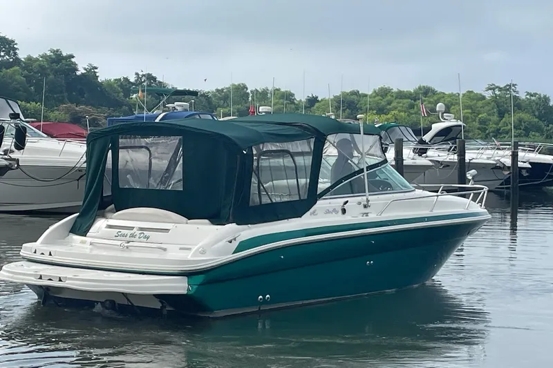 Slide: The Image of 2001 Sea Ray 280 Sun Sport boat docked in a marina with green canopy. - 4