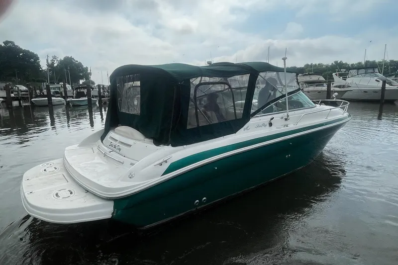 Slide: The Image of 2001 Sea Ray 280 Sun Sport boat docked in a marina, featuring a green canopy. - 5