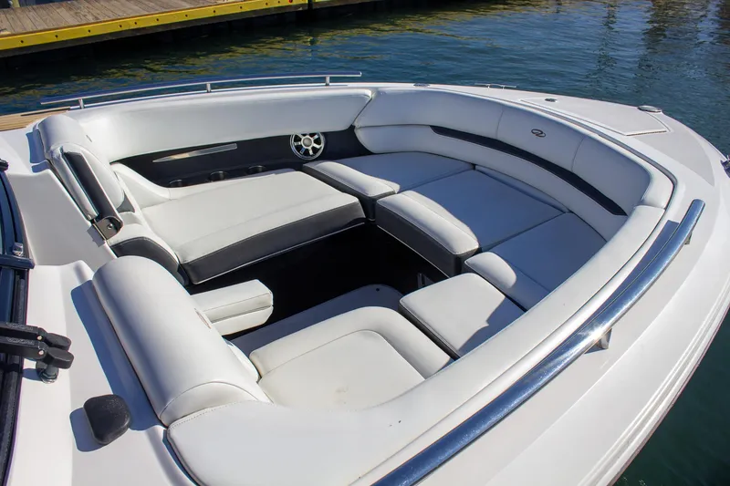 Slide: The Image of 2015 Regal 2800 boat interior with white seating, docked on calm water. - 11