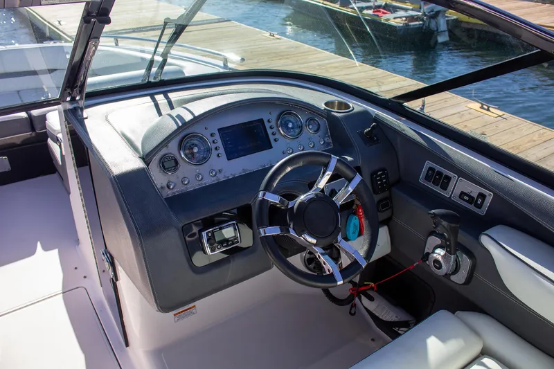Slide: The Image of 2015 Regal 2800 boat dashboard with steering wheel and control panel at dock. - 18
