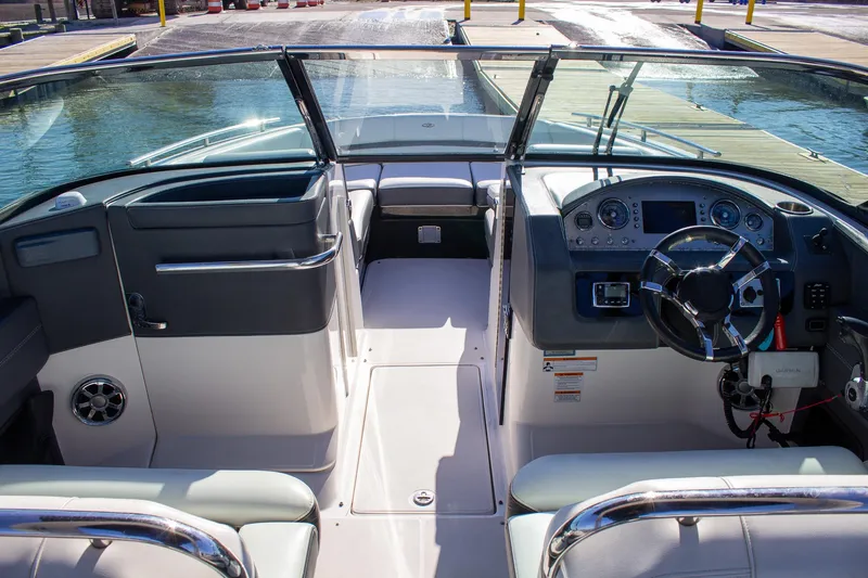 Slide: The Image of 2015 Regal 2800 boat interior with steering wheel and dashboard, docked by the water. - 19