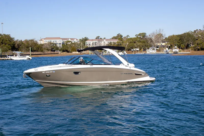 The Image of 2015 Regal 2800 boat cruising on a sunny day in a scenic waterway. - 2