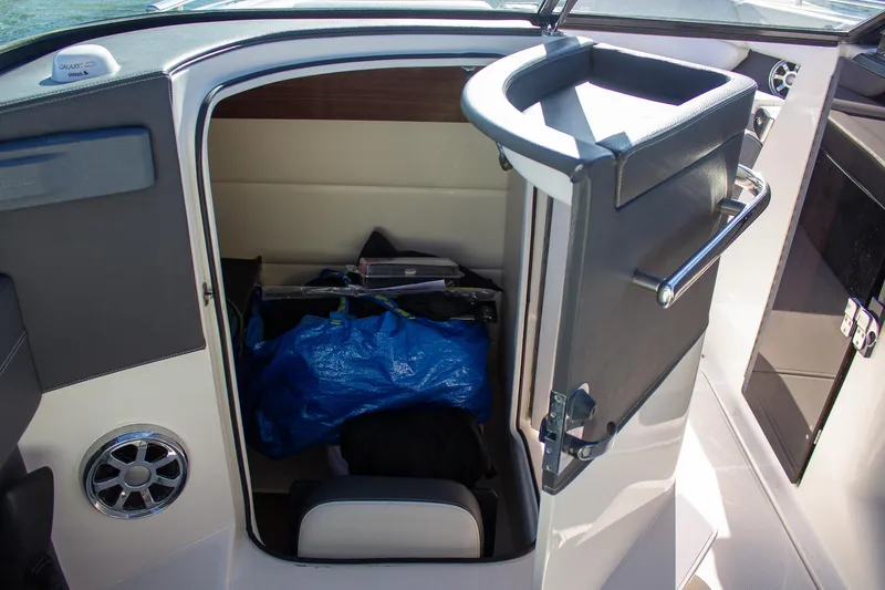 Slide: The Image of 2015 Regal 2800 boat storage compartment with blue bag inside. - 20