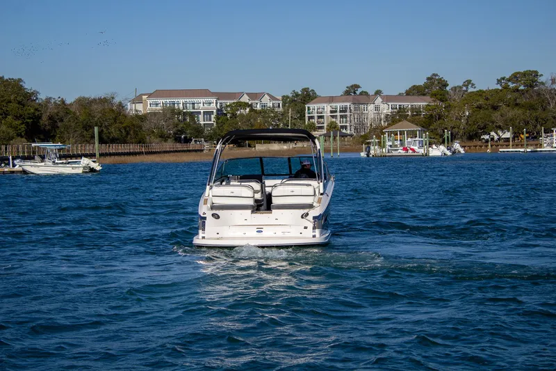 Slide: The Image of 2015 Regal 2800 boat cruising on a sunny day near waterfront homes. - 4