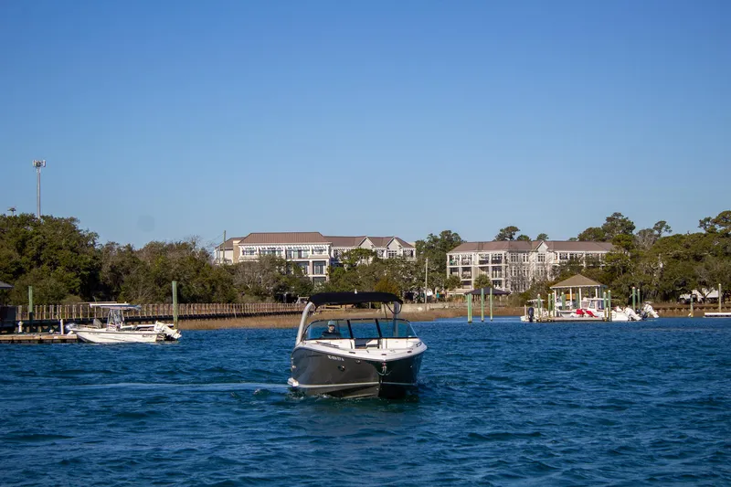 Slide: The Image of 2015 Regal 2800 boat cruising on a scenic waterway near residential buildings. - 9