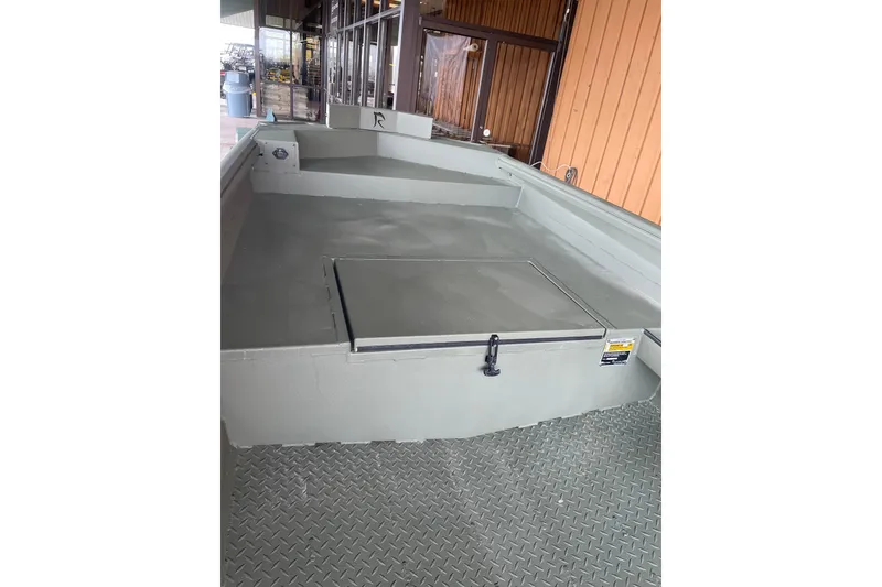 Slide: The Image of 2026 Reaper Boats 653 Timber Reaper, interior view with storage compartment, displayed outdoors. - 17