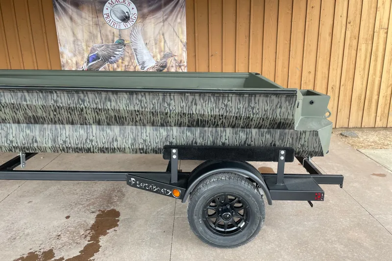 Slide: The Image of 2026 Reaper Boats 653 Timber Reaper on trailer, camouflage design, displayed outdoors. - 6