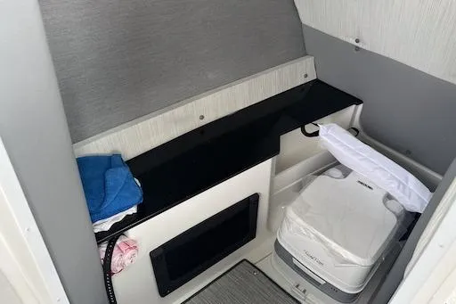 Slide: The Image of 2024 Cobalt R8 boat interior with compact toilet and storage area. - 14