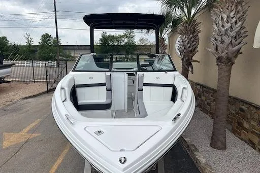 Slide: The Image of 2024 Cobalt R8 boat with sleek white design, docked near palm trees. - 2