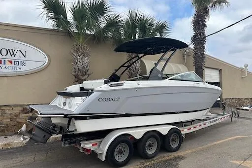 Slide: The Image of 2024 Cobalt R8 boat on trailer, parked near palm trees and a yacht dealership. - 4