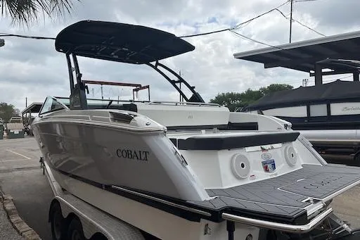 Slide: The Image of 2024 Cobalt R8 boat with sleek design, docked on a trailer under cloudy skies. - 6