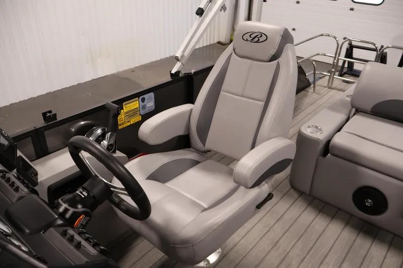 Slide: The Image of 2025 Bentley Pontoons 223 Swingback captain's chair and helm, featuring luxurious gray upholstery. - 29