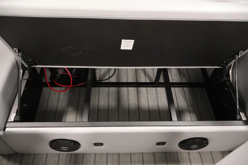 Slide: The Image of 2025 Bentley Pontoons 223 Swingback storage compartment with open lid and visible wiring. - 32