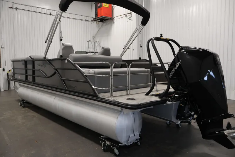 Slide: The Image of 2025 Bentley Pontoons 223 Swingback in a showroom, featuring a sleek design and Mercury engine. - 7