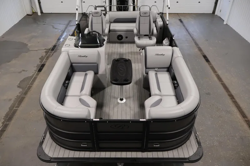 Slide: The Image of 2025 Bentley Pontoons 223 Swingback with luxurious seating and sleek design in a showroom. - 9