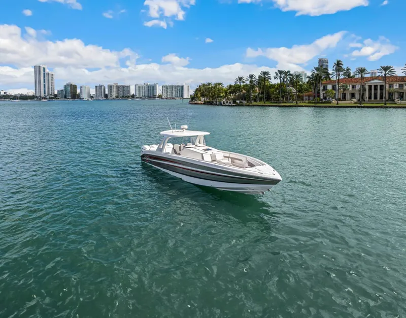 Slide: The Image of 2015 Cigarette 41' GTR boat on calm water near coastline. - 3