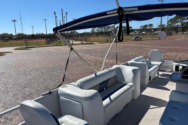 Slide: The Image of 2004 Crest 2200 Family DL pontoon boat with blue canopy in a sunny parking lot. - 11