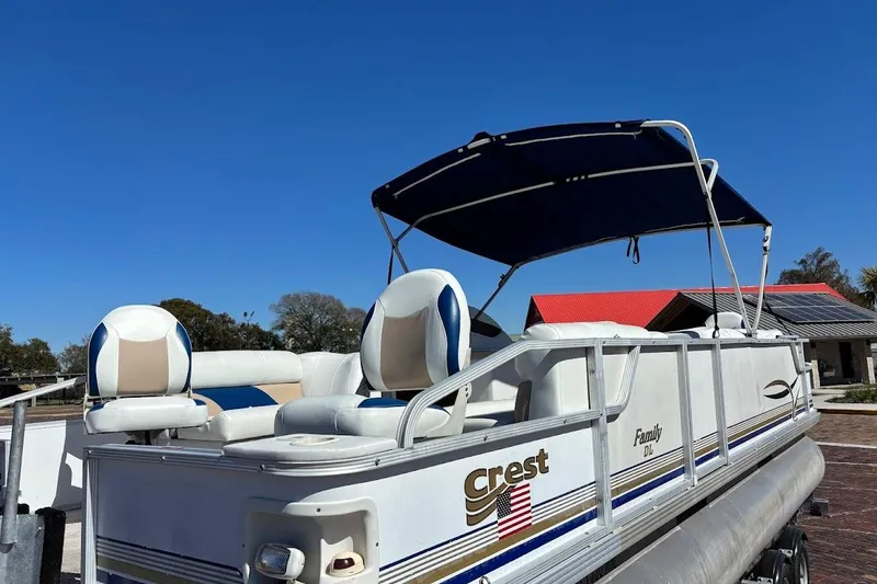 Slide: The Image of 2004 Crest 2200 Family DL pontoon boat with canopy, parked outdoors under clear blue sky. - 5