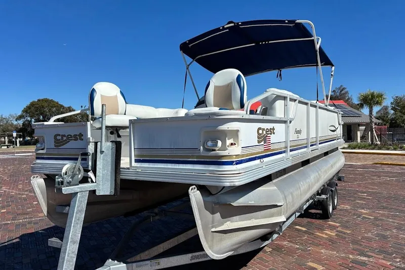 Slide: The Image of 2004 Crest 2200 Family DL pontoon boat on trailer, blue canopy, sunny day. - 6