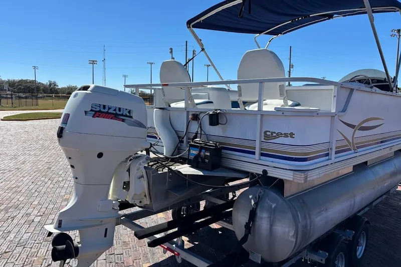 Slide: The Image of 2004 Crest 2200 Family DL pontoon boat with Suzuki outboard motor on a trailer. - 7