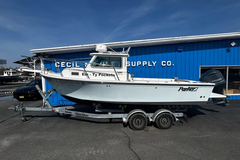 The Image of 2019 Parker 2320 Sport Cabin boat on trailer outside marine supply store. - 0