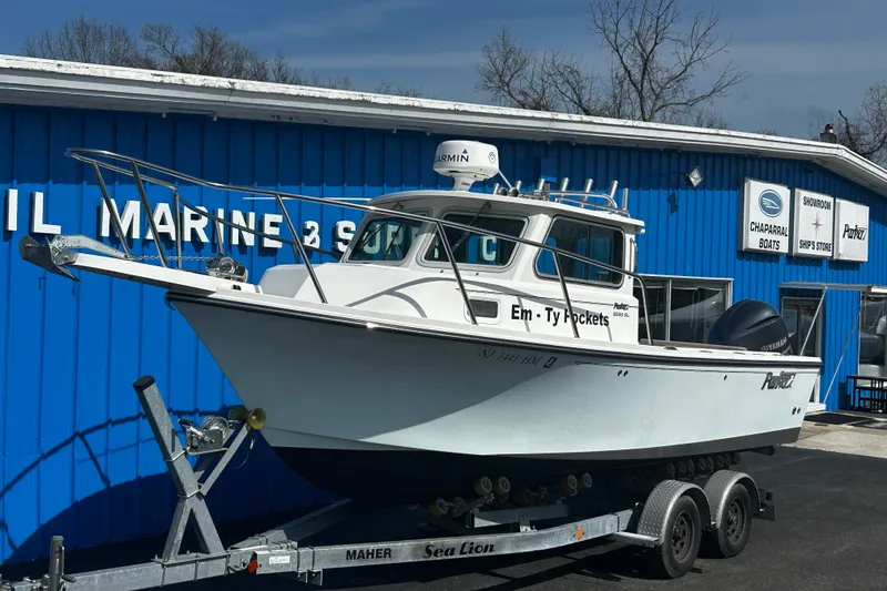 Slide: The Image of 2019 Parker 2320 Sport Cabin boat on trailer outside marine showroom. - 1