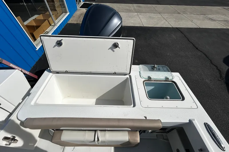 Slide: The Image of 2019 Parker 2320 Sport Cabin boat with open storage compartments and seating. - 10