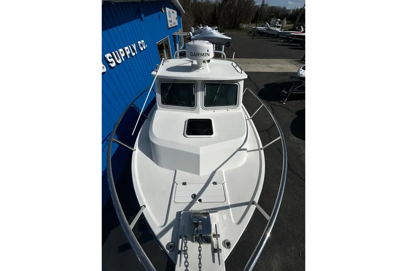 Slide: The Image of 2019 Parker 2320 Sport Cabin boat with Garmin radar, docked near blue building. - 11