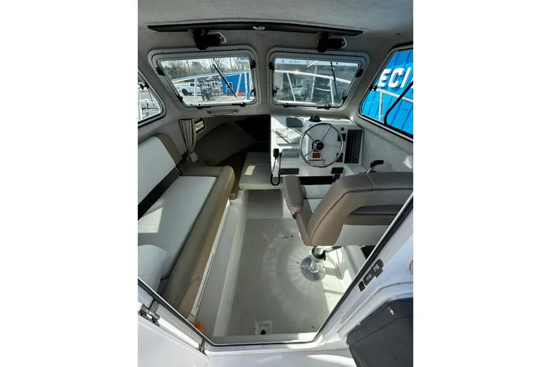 Slide: The Image of Interior of a 2019 Parker 2320 Sport Cabin boat, featuring helm and seating area. - 15