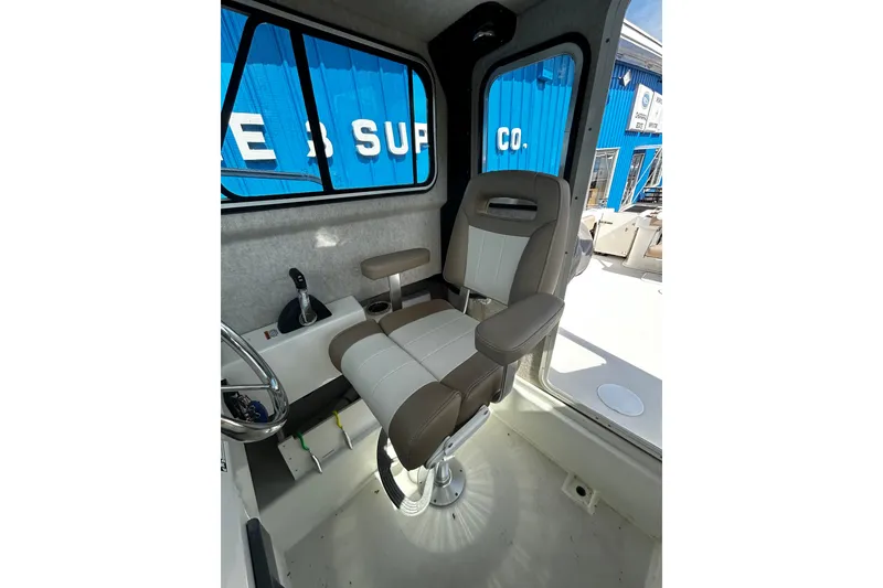 Slide: The Image of Interior of 2019 Parker 2320 Sport Cabin boat with captain's chair and controls. - 16