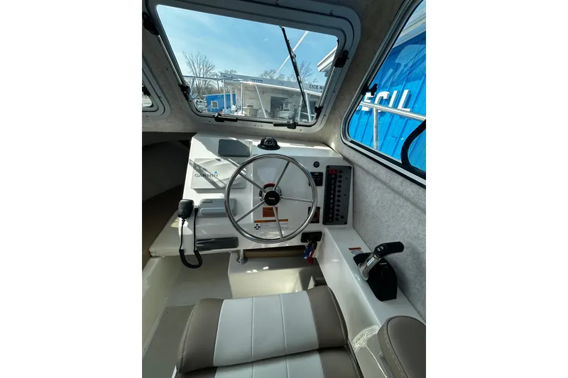 Slide: The Image of 2019 Parker 2320 Sport Cabin interior with steering wheel and control panel. - 17