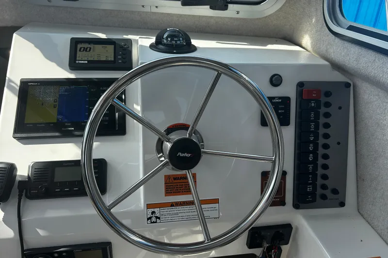 Slide: The Image of 2019 Parker 2320 Sport Cabin dashboard with steering wheel and navigation instruments. - 18