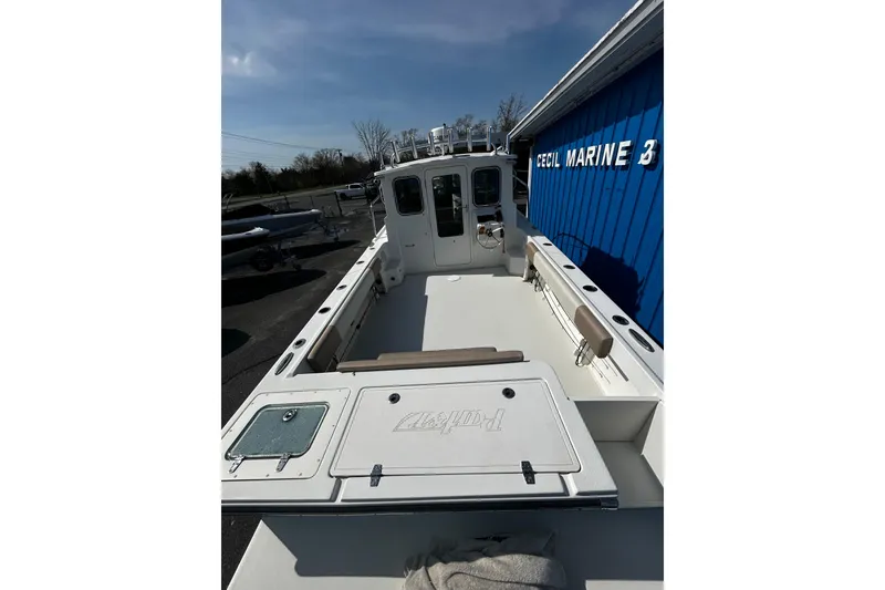 Slide: The Image of 2019 Parker 2320 Sport Cabin boat at dockside, blue building background. - 4