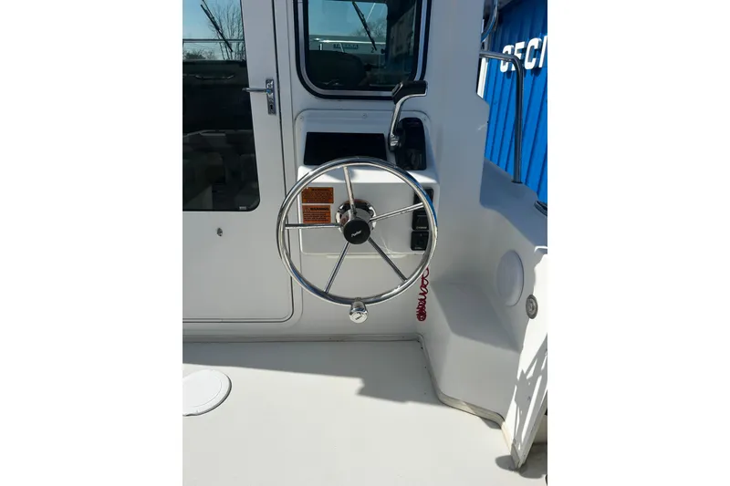 Slide: The Image of Steering wheel of a 2019 Parker 2320 Sport Cabin boat, showcasing cockpit details. - 6
