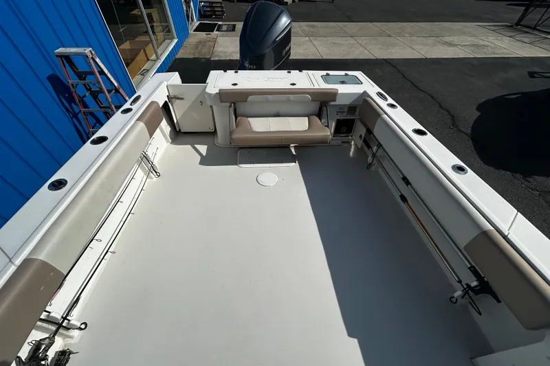 Slide: The Image of 2019 Parker 2320 Sport Cabin boat deck with seating and fishing rod holders. - 8