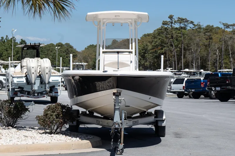 Slide: The Image of 2017 Robalo 246 Cayman boat on trailer in parking lot, surrounded by trees and vehicles. - 3