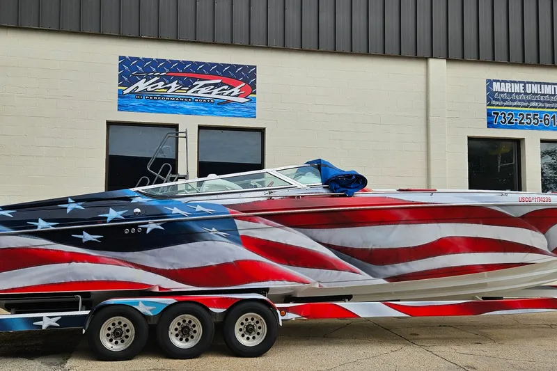 Slide: The Image of 2004 Formula 382 FASTech boat with American flag design, parked outside a marine service shop. - 2
