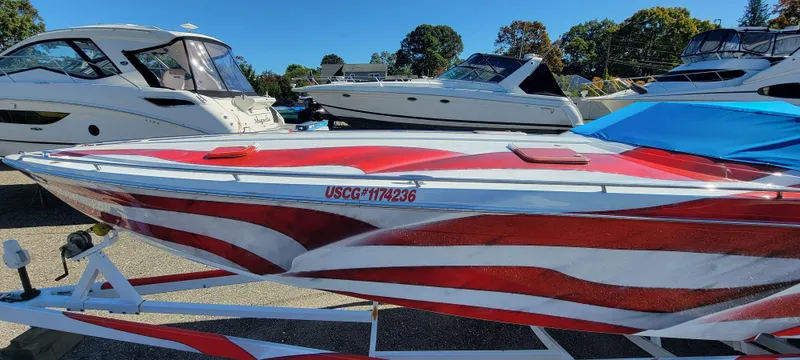 Slide: The Image of 2004 Formula 382 FASTech boat with red and white design, docked among other boats. - 7