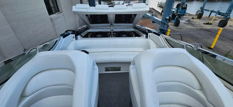 Slide: The Image of 2004 Formula 382 FASTech boat interior with white leather seating and open engine compartment. - 9